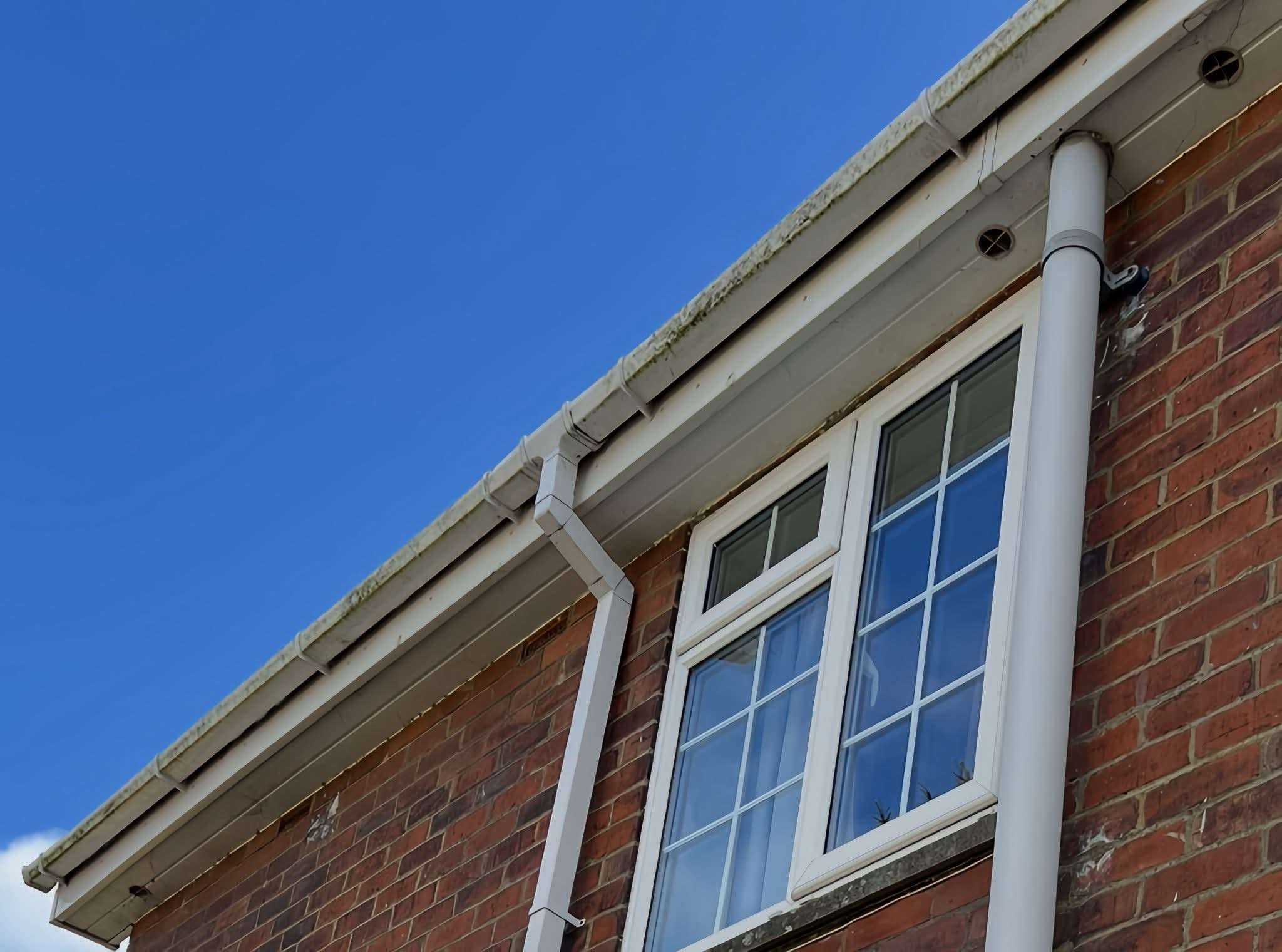Gutter bracket and outlet at the eaves